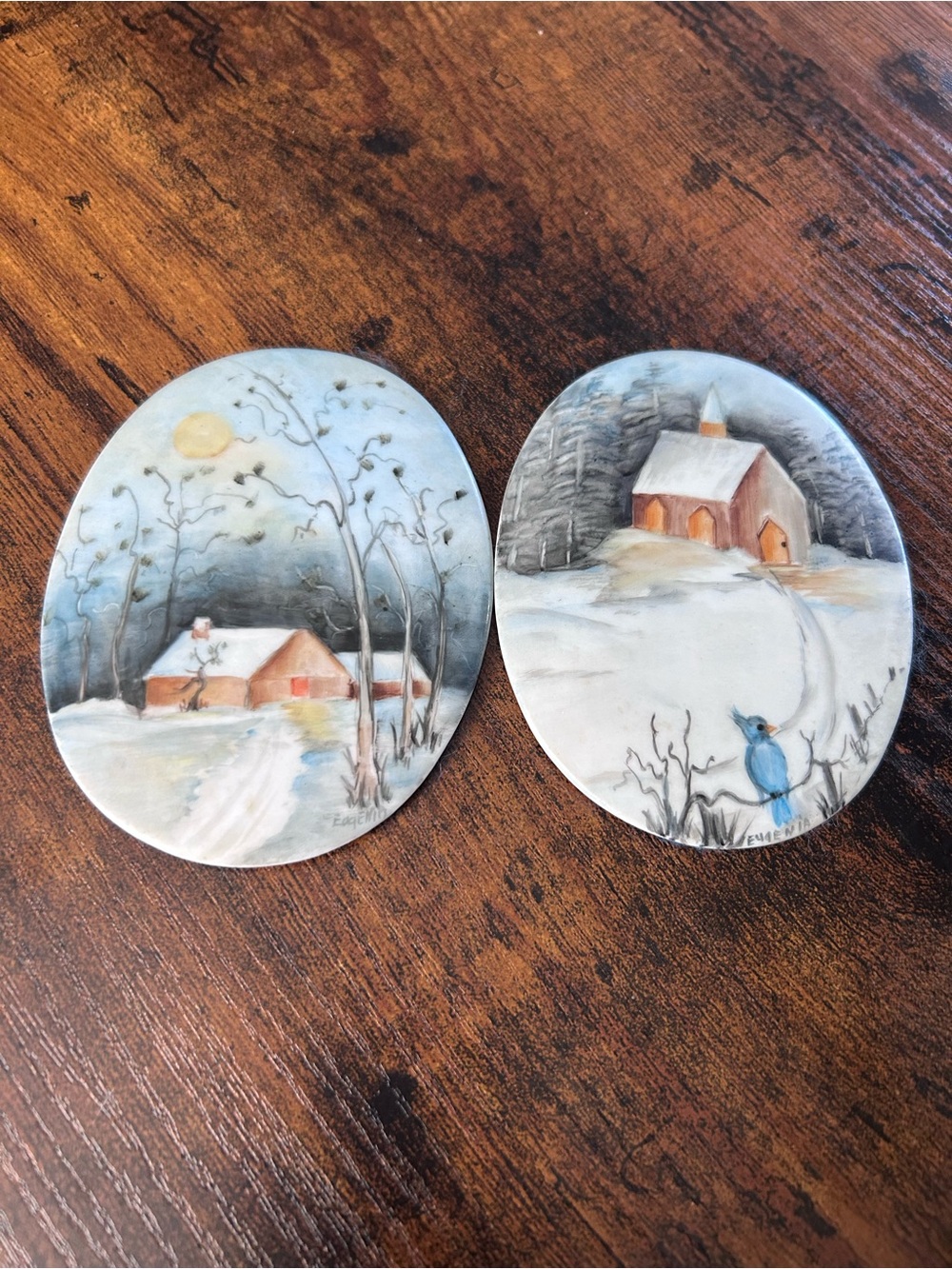 hand-painted oval porcelain plaques featuring cozy, winter folk art scenes